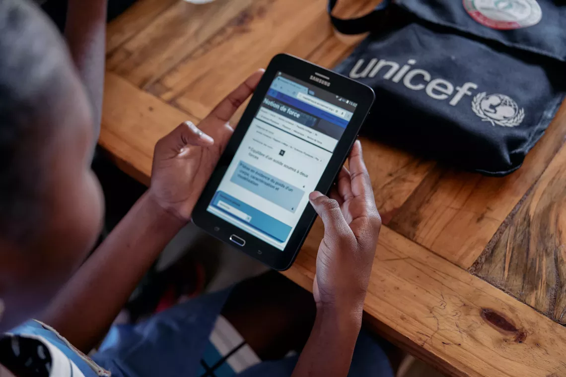 A 1st-year secondary student, using a tablet to access online courses. 