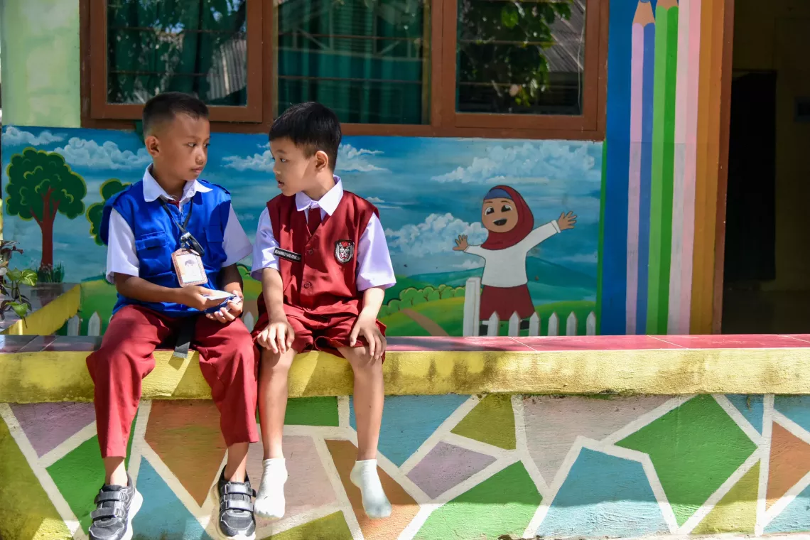 On 15 August 2023, Sulfitrah M (left), age 10, explains hygiene promotion to his younger classmate Muhammad Farid Athallah (right) age 7 at their school in Maros, South Sulawesi Province, Indonesia.