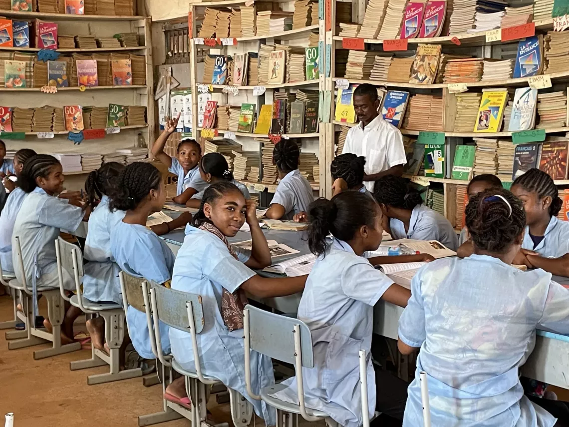 Students focused at their desks in a classroom setting, participating in educational discussions
