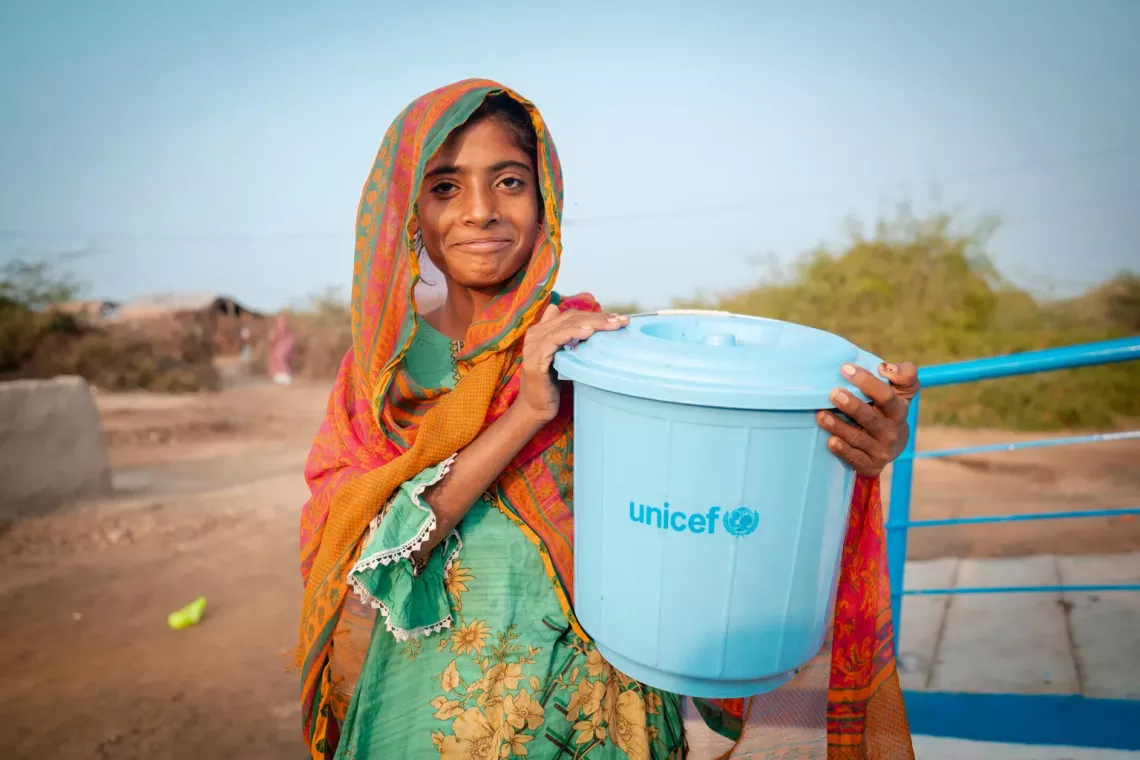 Une petite fille au Pakistan tient dans ses mains un seau fourni par l&rsquo;UNICEF, qui sert &agrave; transporter et &agrave; stocker de l&rsquo;eau potable.