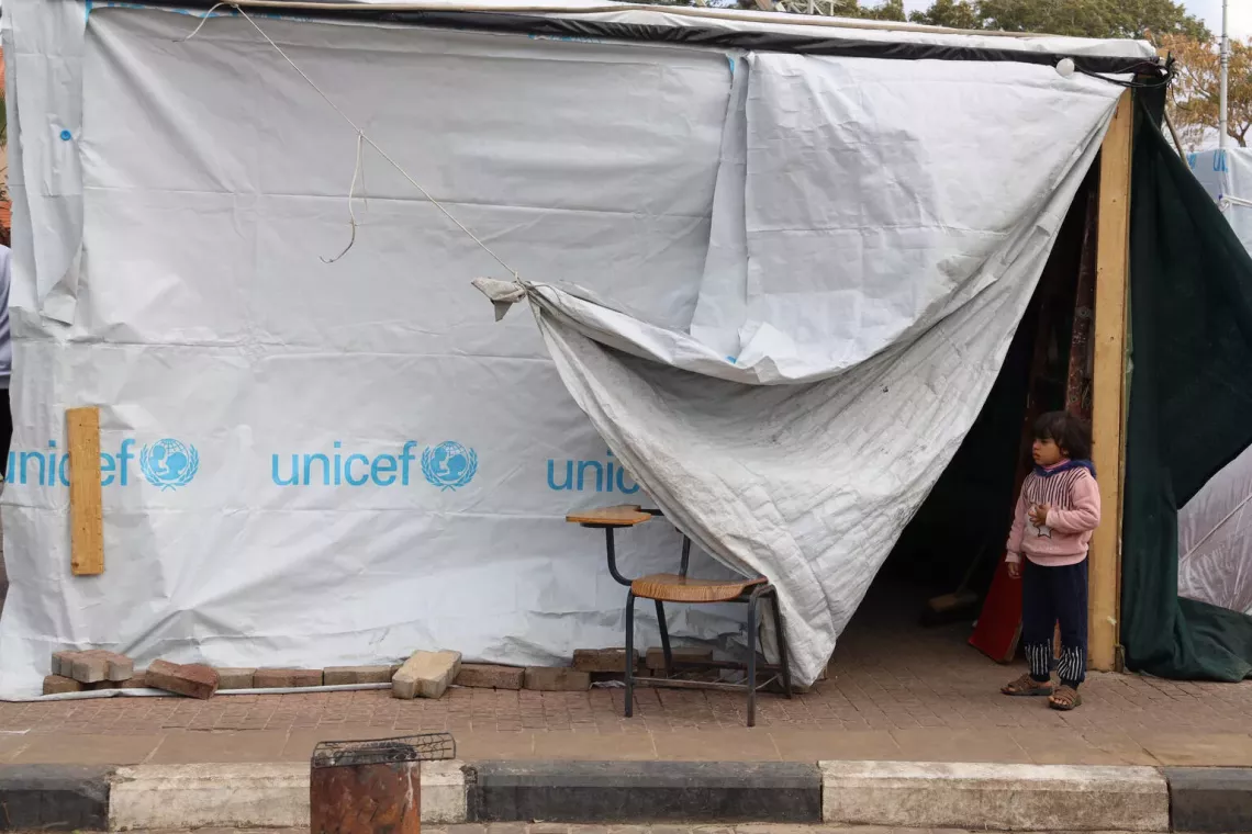 Gaza Strip. A child stands next to a UNICEF tent at a shelter centre in the Gaza Strip.