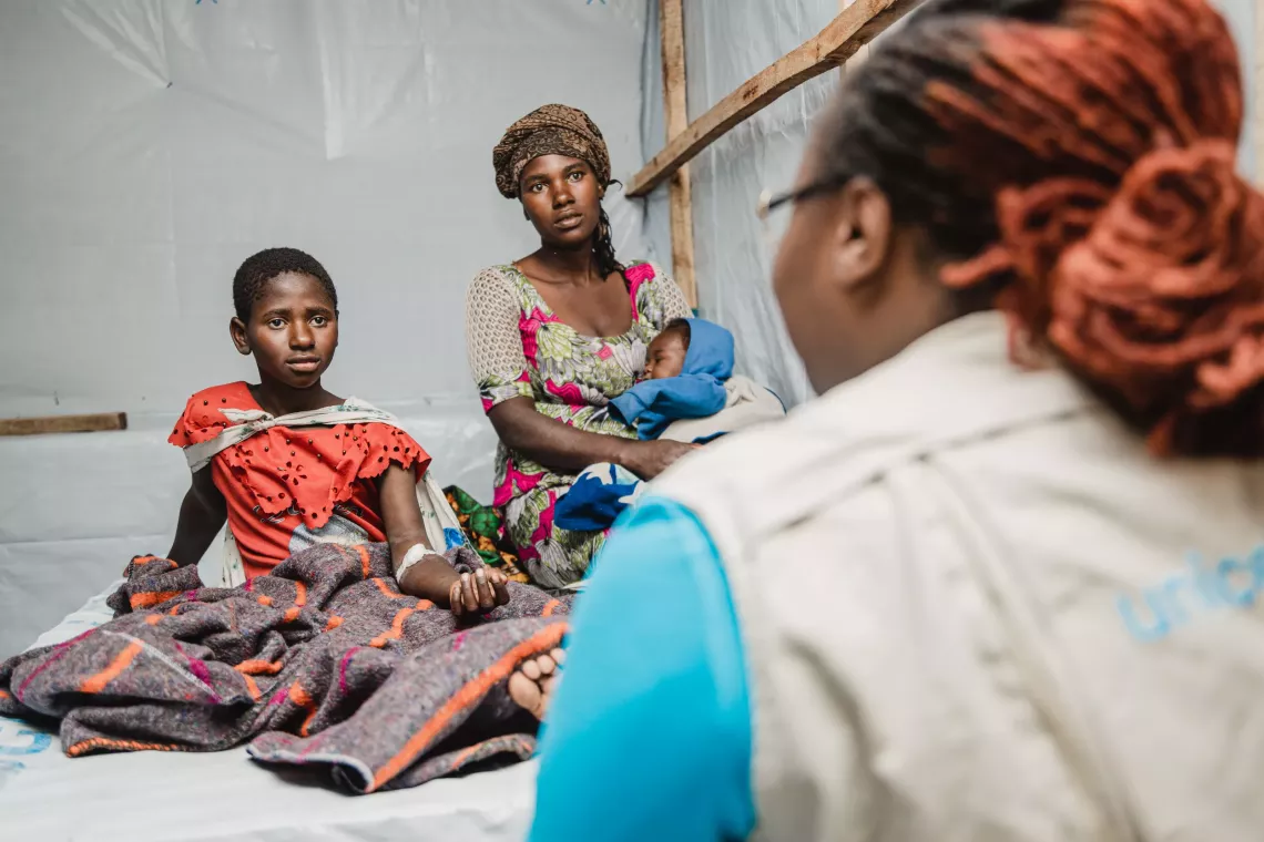 A young patient and her mother talk to UNICEF staff at the Afya Sake Cholera Treatment Centre (CTC) in North Kivu province, DR Congo, on 12 January 2024.