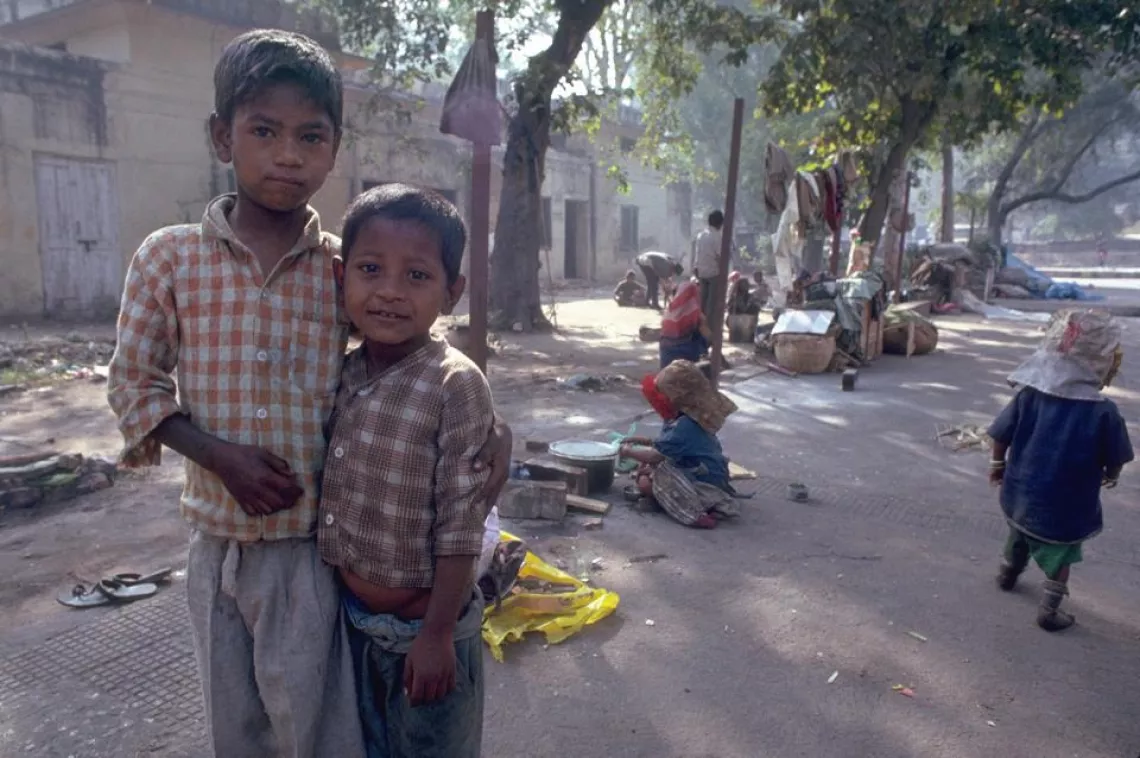 Two children stand in the street.