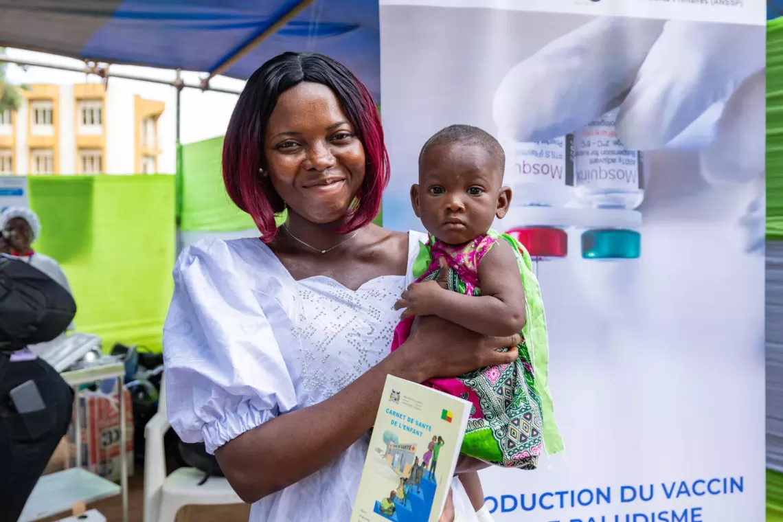 A mother holds her baby at the Allada health center in Benin. Benin was the fourth country to receive doses of RTS,S vaccines after Cameroon, Sierra Leone, and Burkina Faso. 