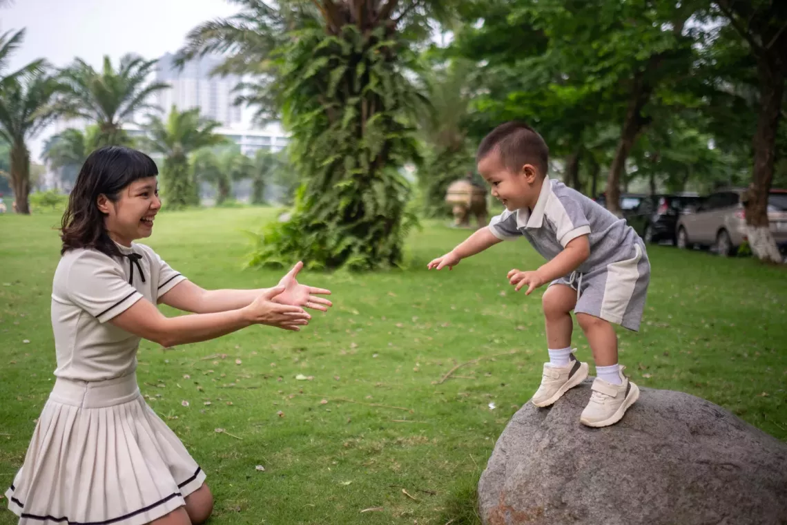 Three-year-old Bui Hoang The Bao gets ready to jump into his mother&rsquo;s outstretched arms as they play at a park in a residential area on the outskirts of Ha Noi, Viet Nam. 