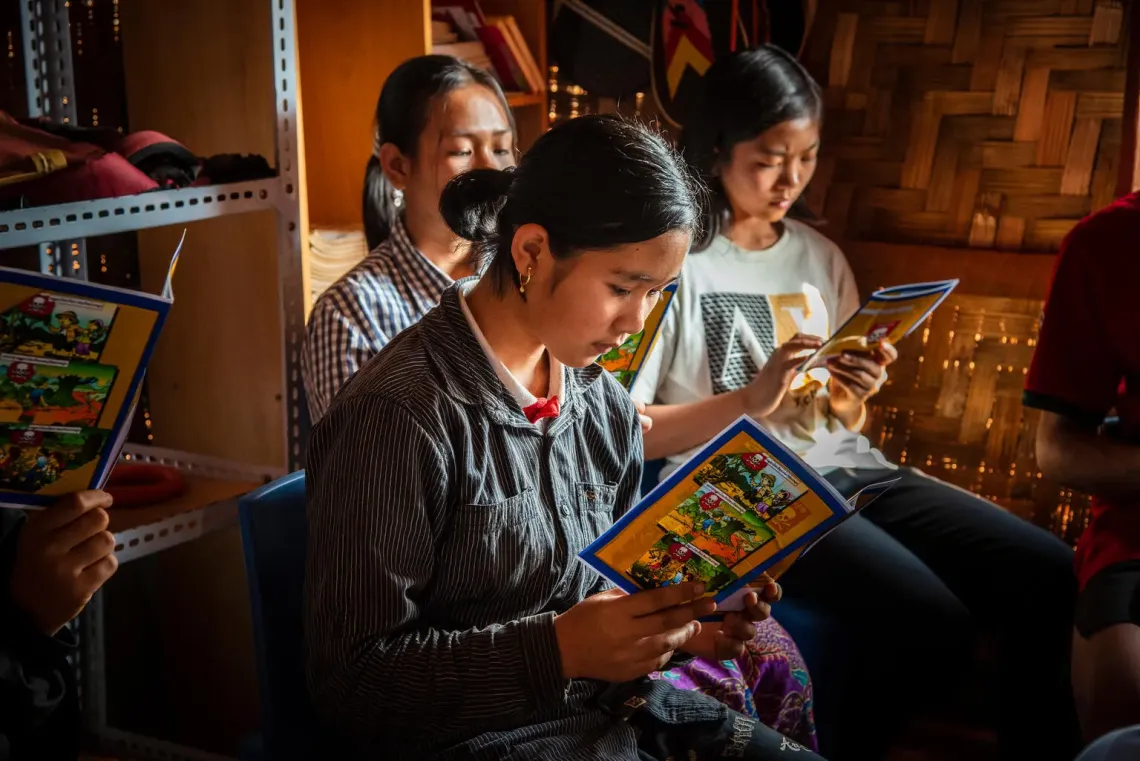 Myanmar. Children read mine risk education brochures during a UNICEF-led awareness session at a temporary learning centre in Shan State.
