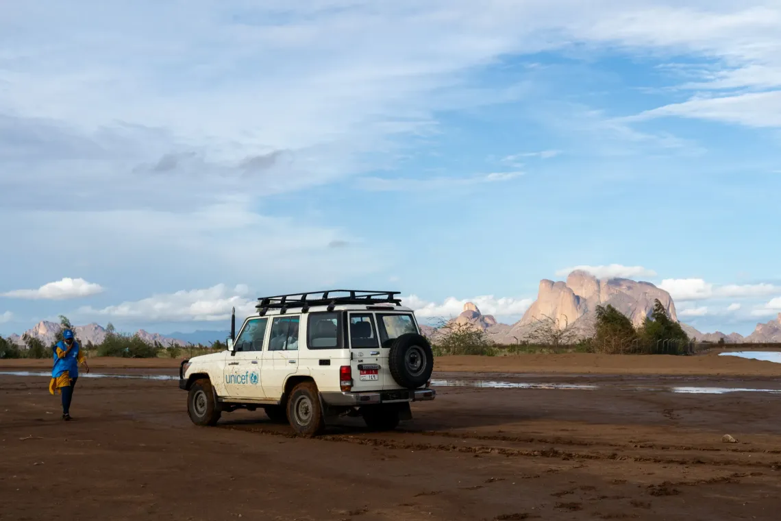 A UNICEF branded vehicle and worker in Sudan landscape