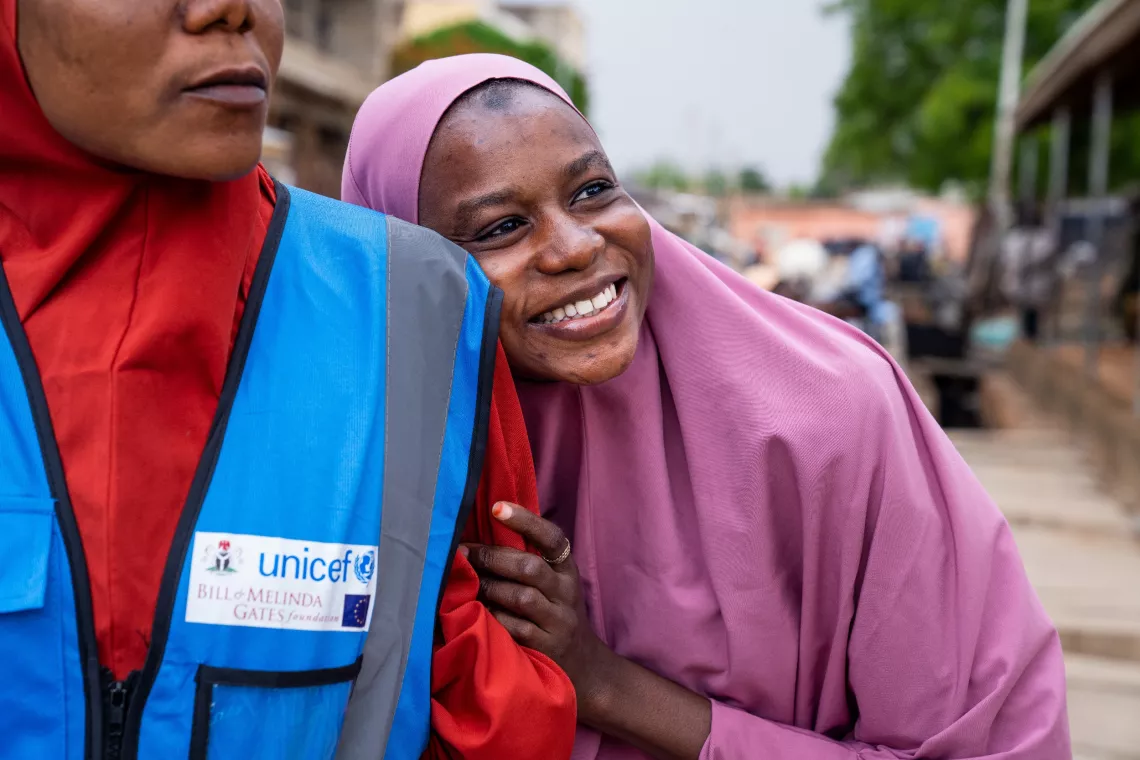 Hadiza leans on her sister's arm as she accompanies her to educate local families about the human papillomavirus (HPV) vaccine rollout in Katsina, Nigeria.