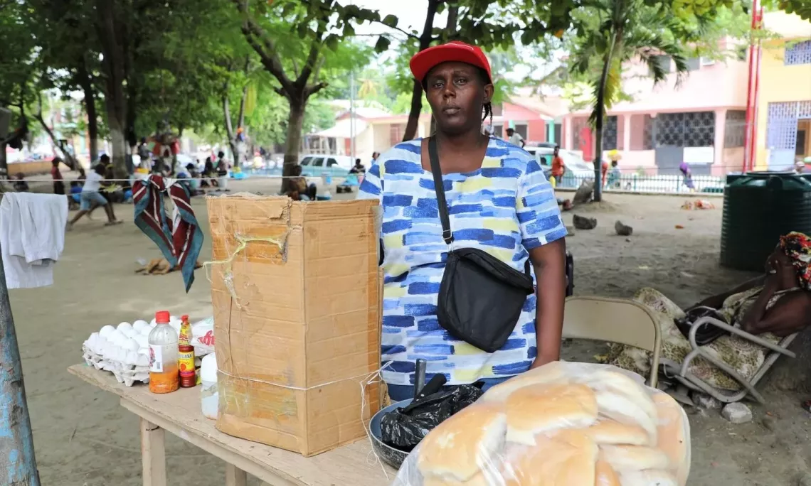 Haiti. A woman stands next to some of the items she plans to sell.