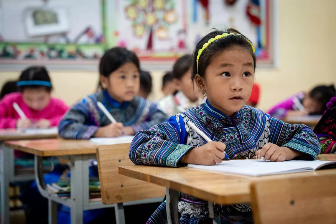30 September 2024 - Children of the Mong ethnic minority, in Lao Cai province, follow a lesson after the distribution of UNICEF-supplied school backpacks filled with education supplies.