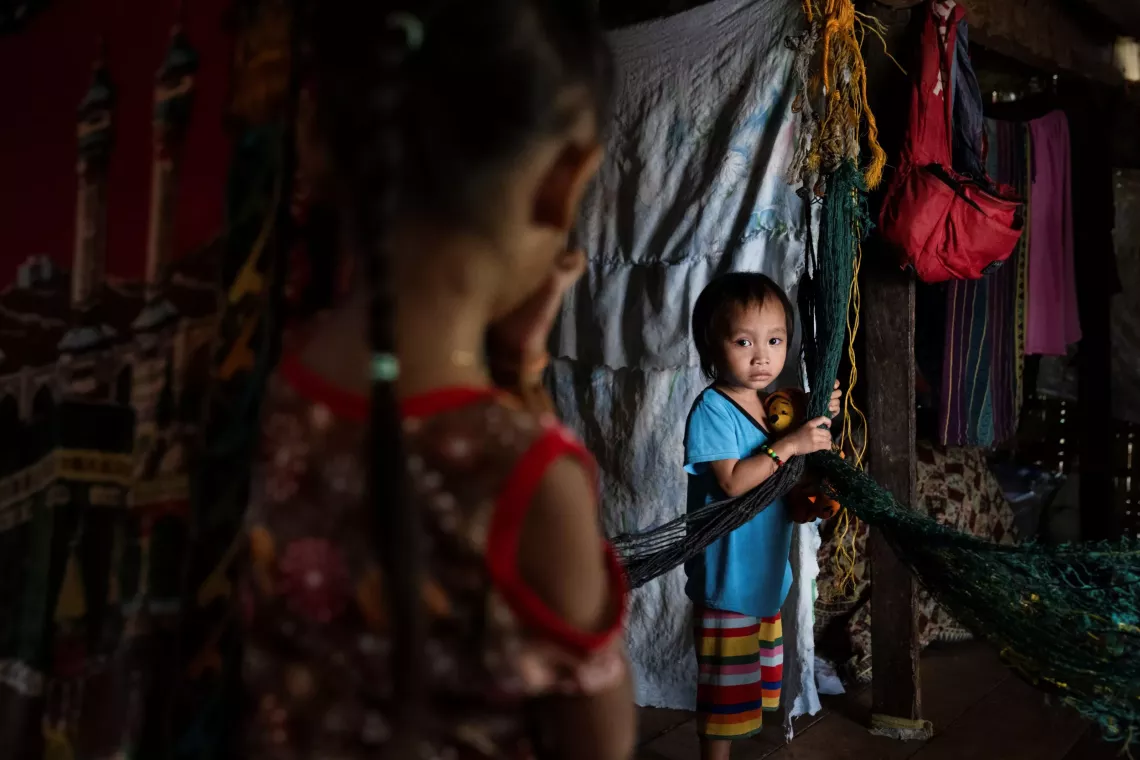 Two children stand inside their home in Cotabato City, Philippines where they live with their extended family. Their cousins were infected with the measles virus during an outbreak in the region. 