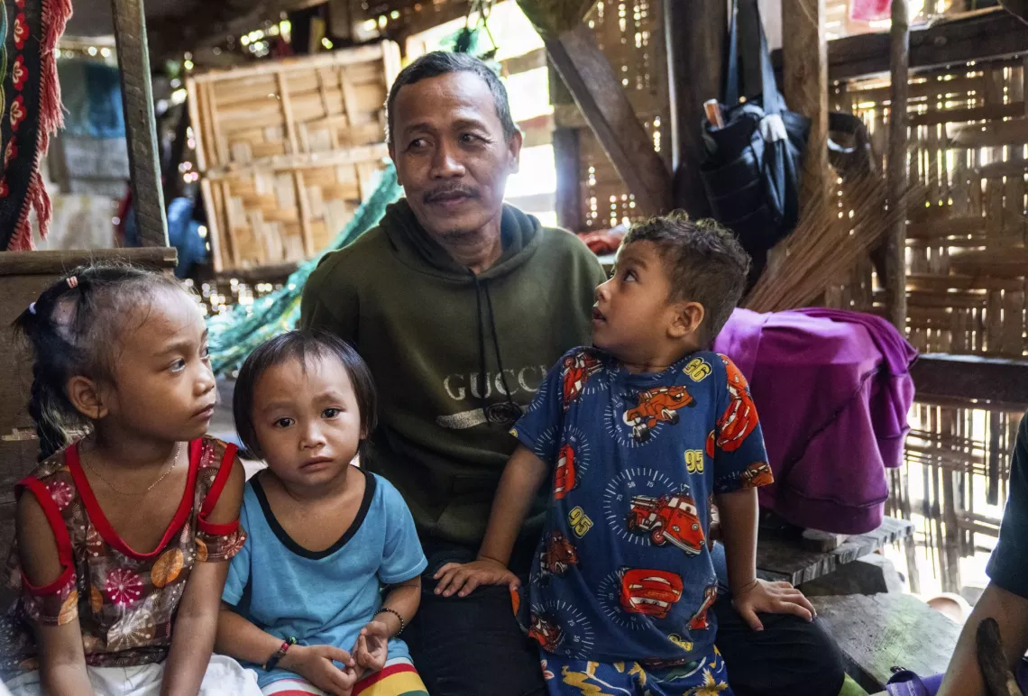 A man with three of his grandchildren around him