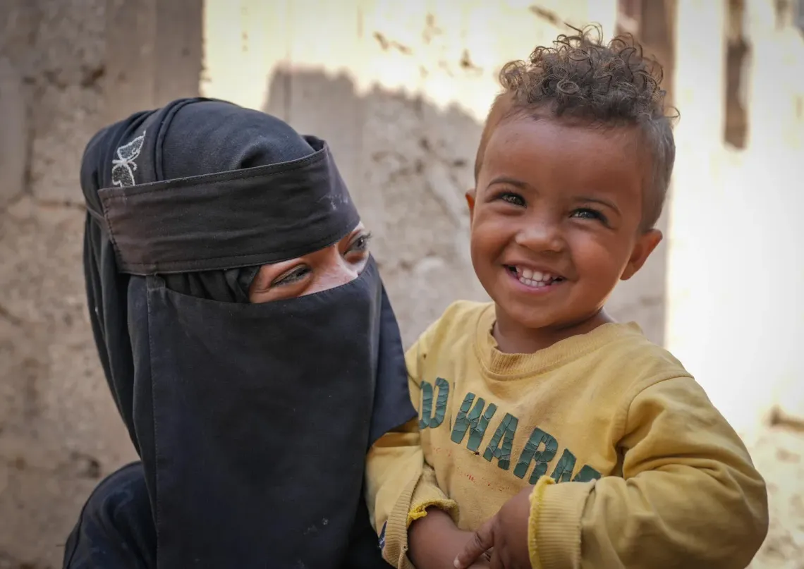 Yemen. A child who recent recovered from severe acute malnutrition smiles at the camera.
