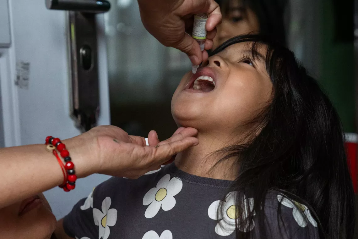 A girl receives an oral polio vaccine