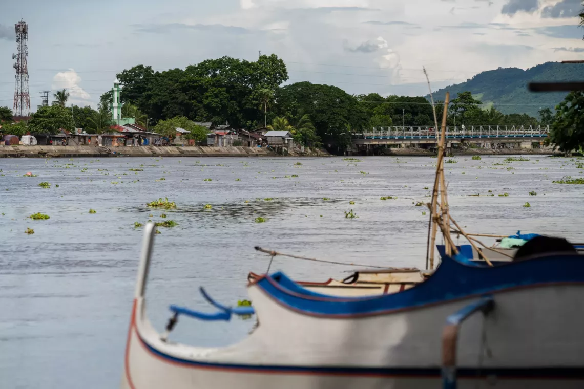 A view cross the river in Cotabato City with boats in the foreground and a mosque in the distance