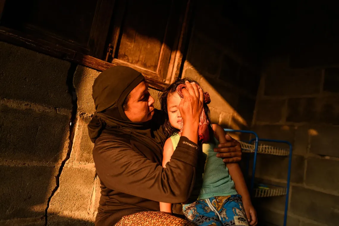 Thailand. A woman wipes the sweat from her granddaughter's forehead in Surin Province, Thailand.