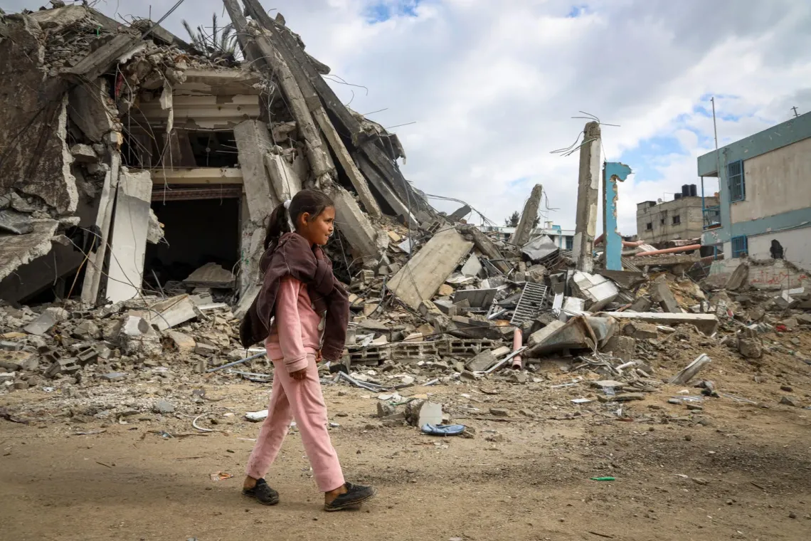 Gaza. A girl walks past the rubble of her destroyed neighborhood in Khan Younis.