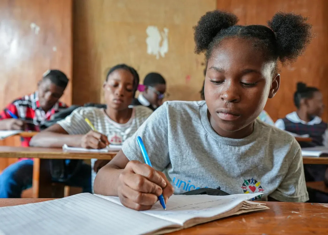 Haiti. Dieussika takes notes during a class.