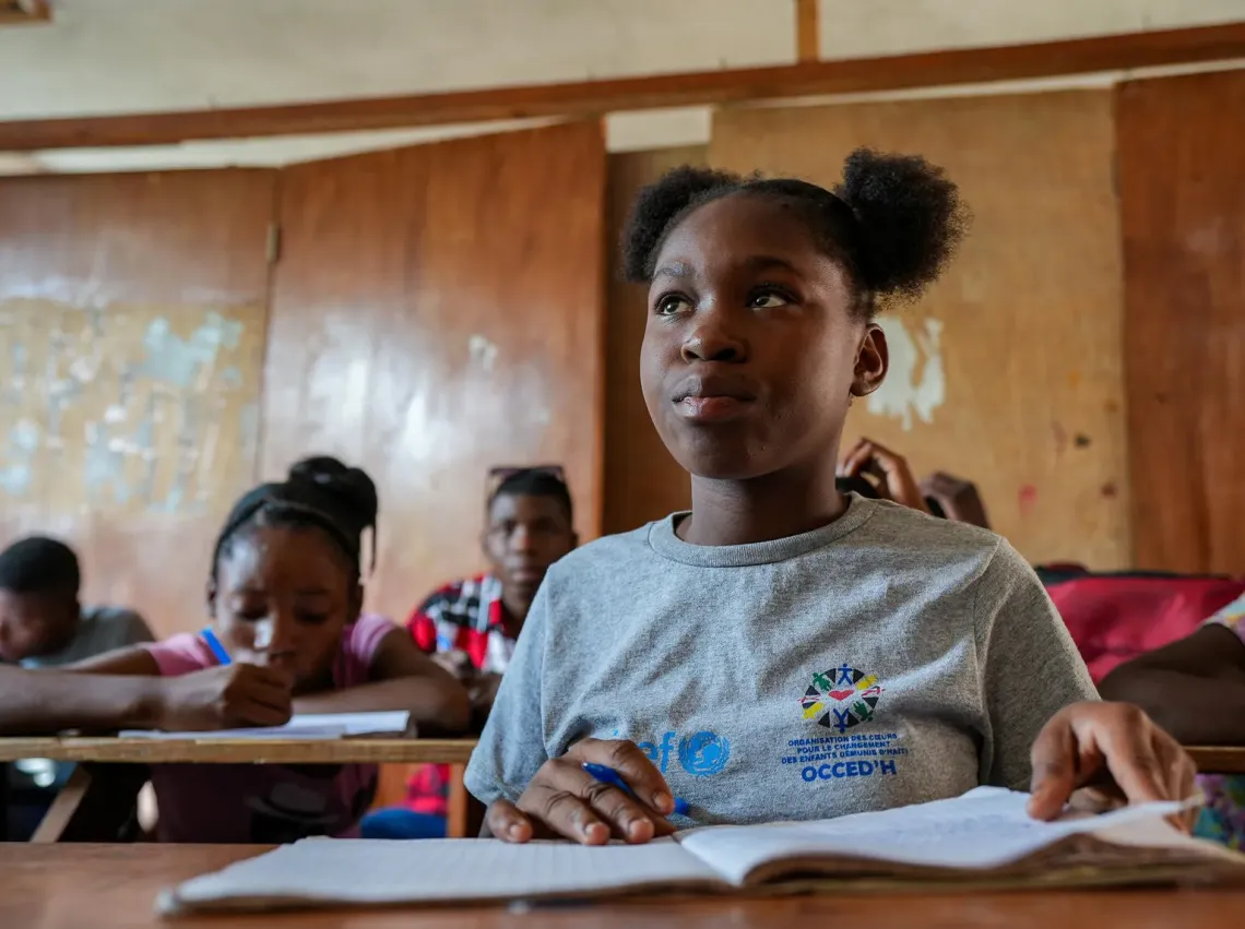 Haiti. A girl sits at a desk in a classroom.