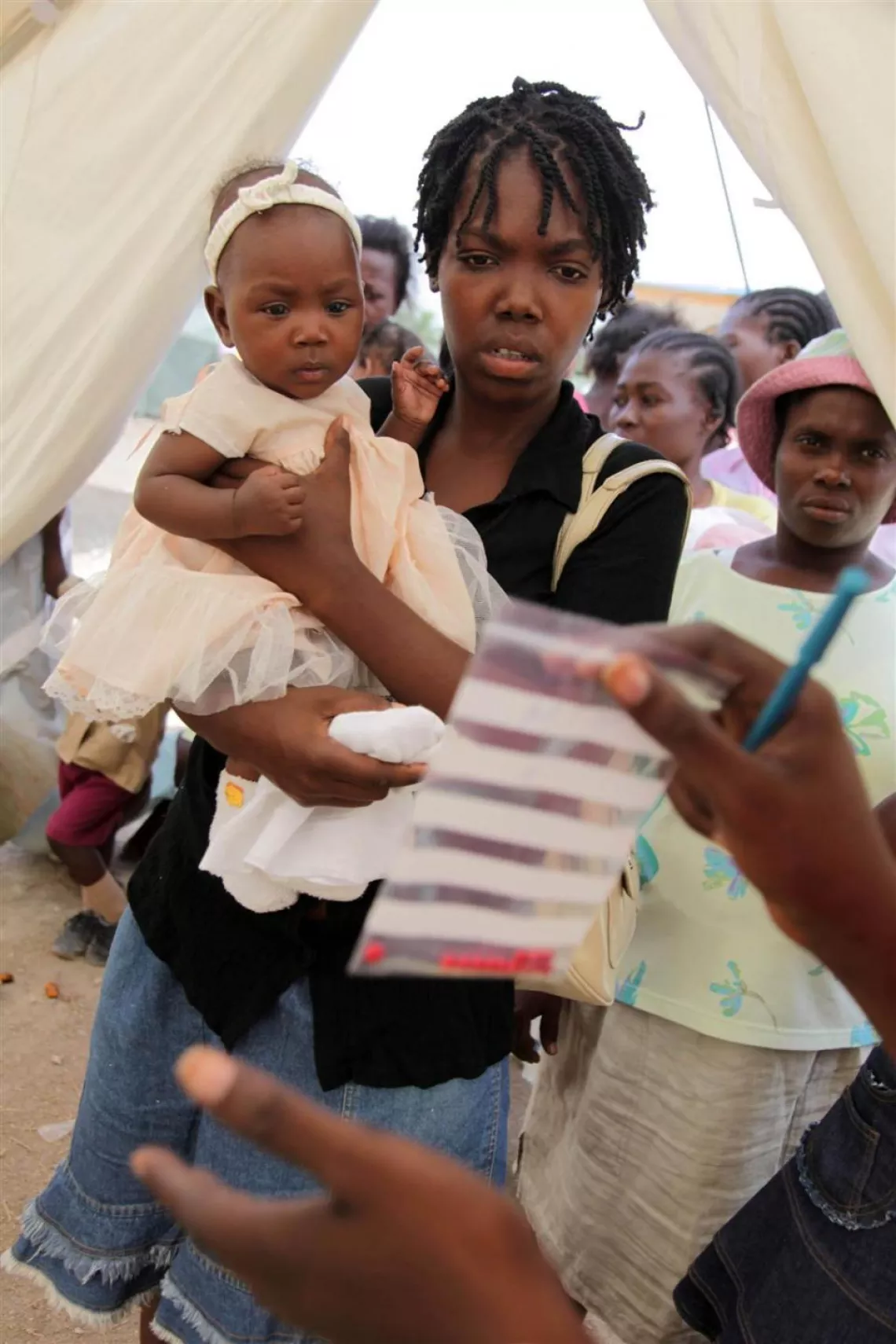 A mother receives antibiotics at a medical tent for displaced earthquake survivors in Jacmel. Haiti, 2010.