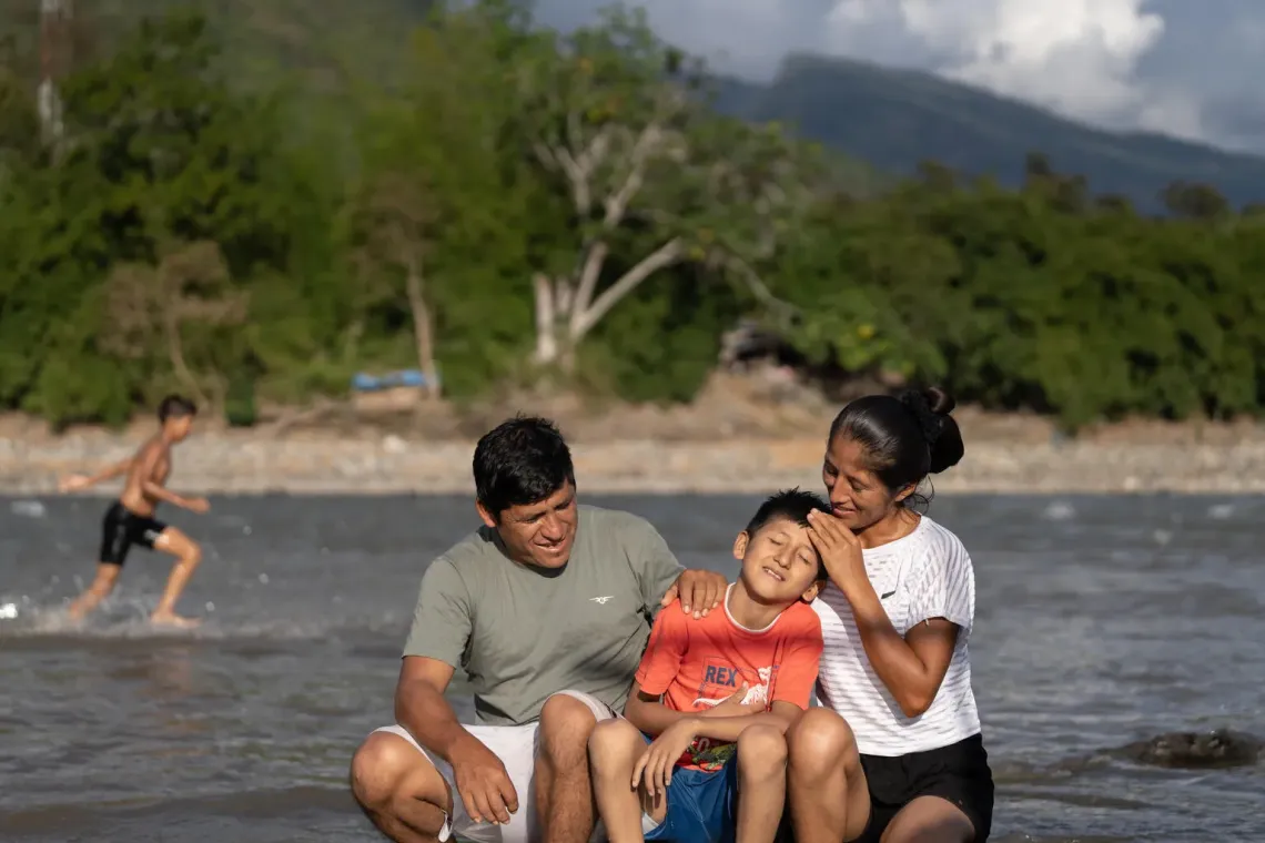 Peru. Hansel sits with his parents, Jhon and Nayci, by the river in Ayacucho.