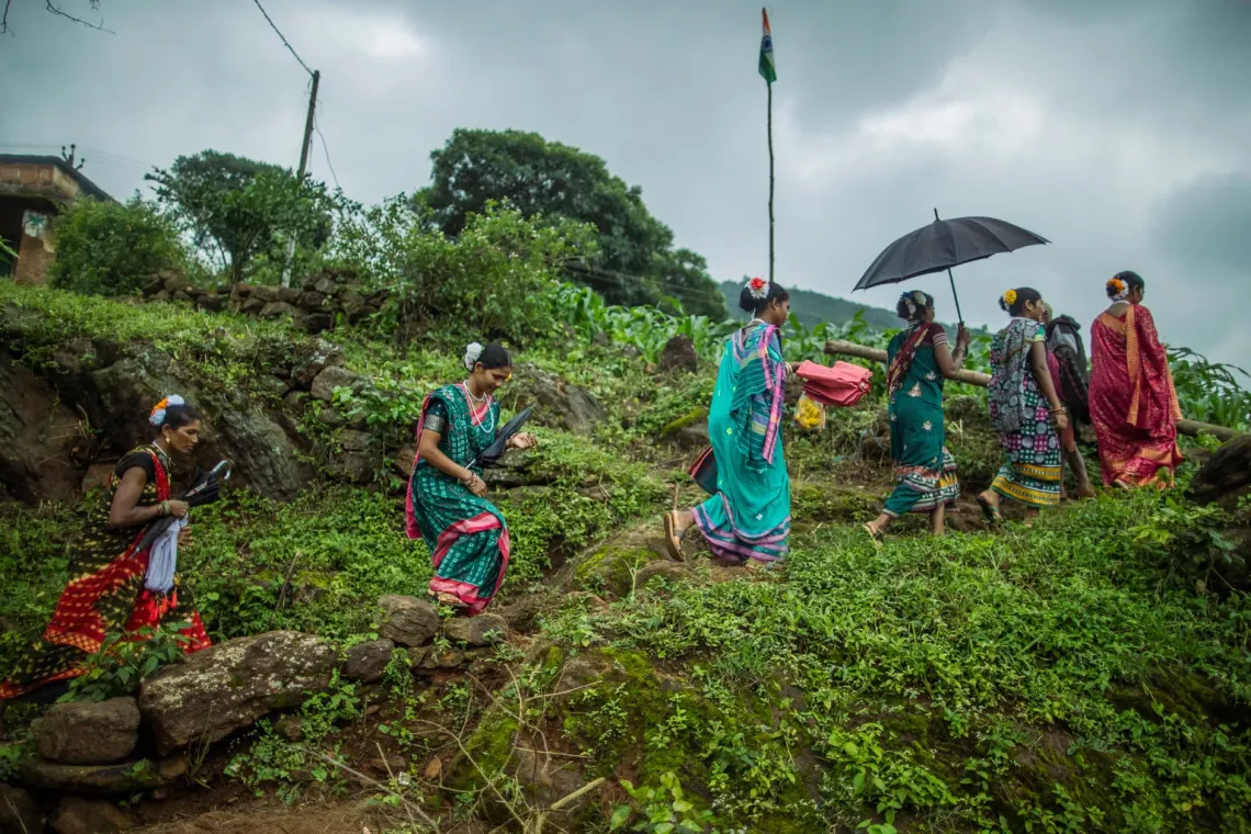 SHG Members walk through a farm to attend an SHG Meeting in Bandaguda village.