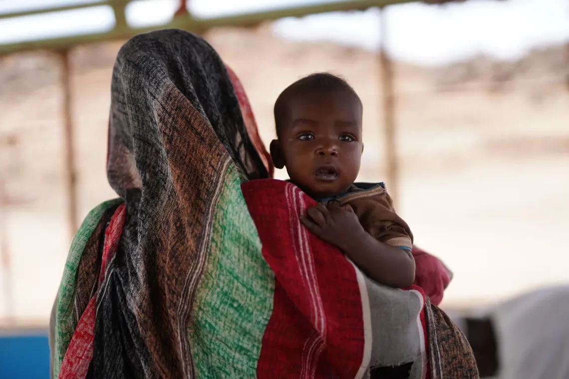 Sudan. A woman holds her child at a UNICEF-supported nutrition centre in Tawila, North Darfur.