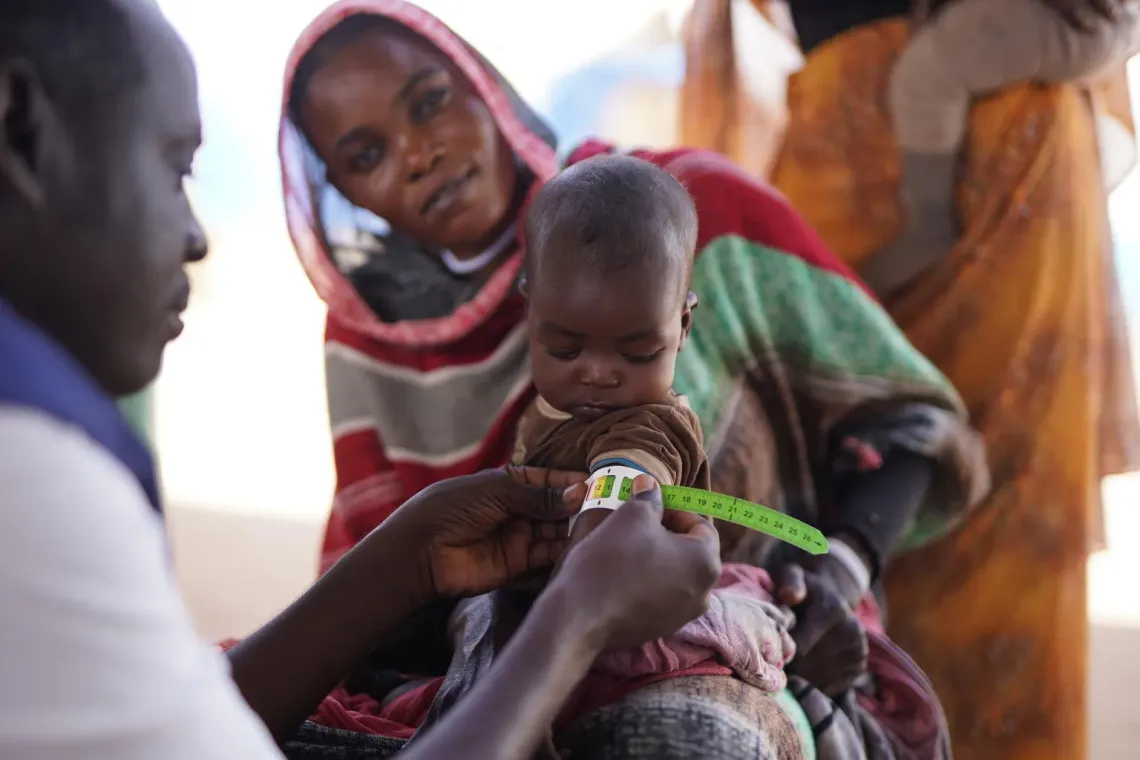 Sudan. A mother holds her daughter as she is screened for malnutrition during a visit to a UNICEF-supported nutrition centre in Tawila.