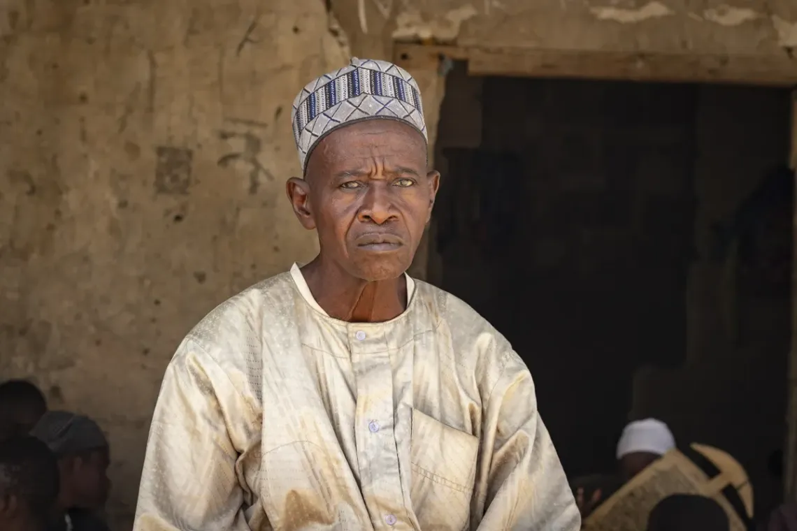 Hula sits with a serious face outside his Tsangaya in Dala, Nigeria.