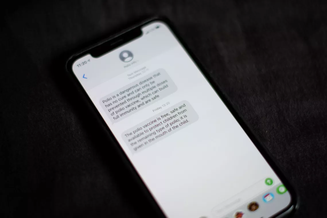 Liberia. An SMS message about polio vaccines is displayed on a phone.