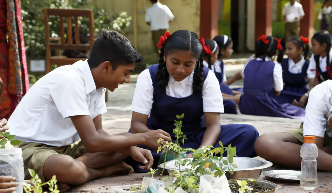 A group of students using polybags from waste and fill them with field soil to grow the saplings for school nursery &nbsp;during environmental activities session at a school in Maharashtra, India
