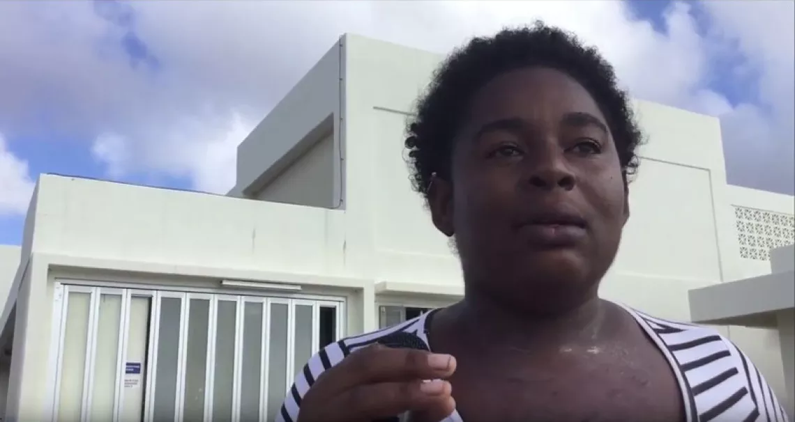 A woman stands in front of a ferry terminal, Barbuda