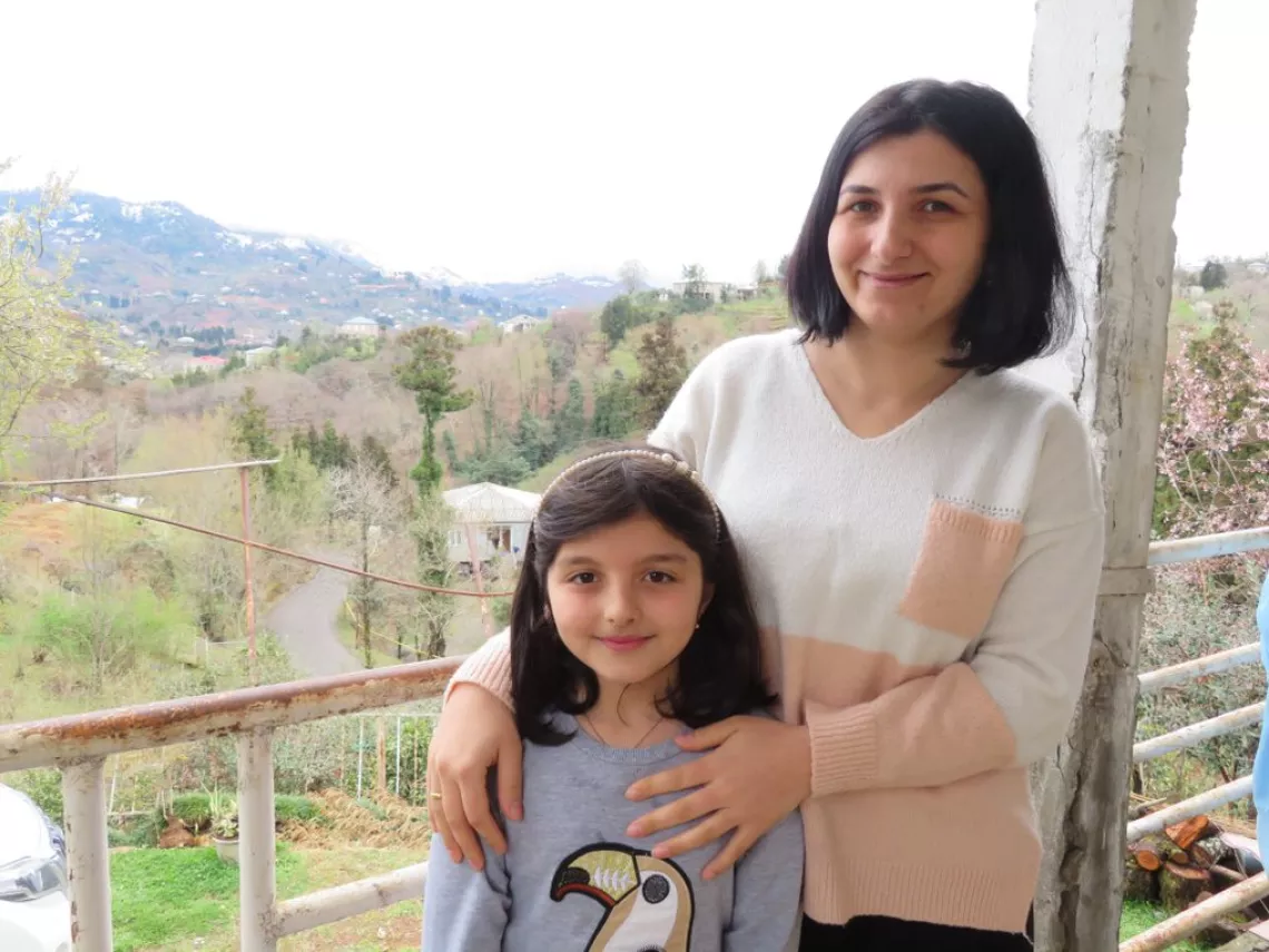Georgia. A woman stands with her daughter.