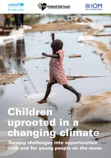 A girl jumps across a pool of water.