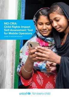 Two young girls looking at a mobil cellphone