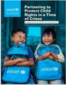 Two 7 years old boys holding their Unicef bags in front of their classroom. 
