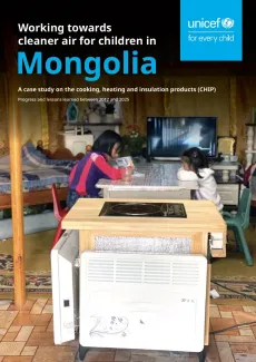 A young girl is studying while her little sister is on the other side of the table. 