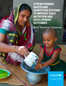 A mother pouring water on her child's hands to wash them