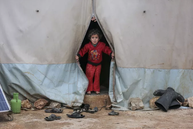 A child looks out of a tent in Kafr Losin Camp in northwest Syria on the 19 January 2021