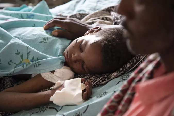 On 17 July 2021, Shumuye, 10, rests on a hospital bed with his father Barhe Atsma at his side in Ayder Hospital in Mekelle, the capital of the Tigray region in Ethiopia.