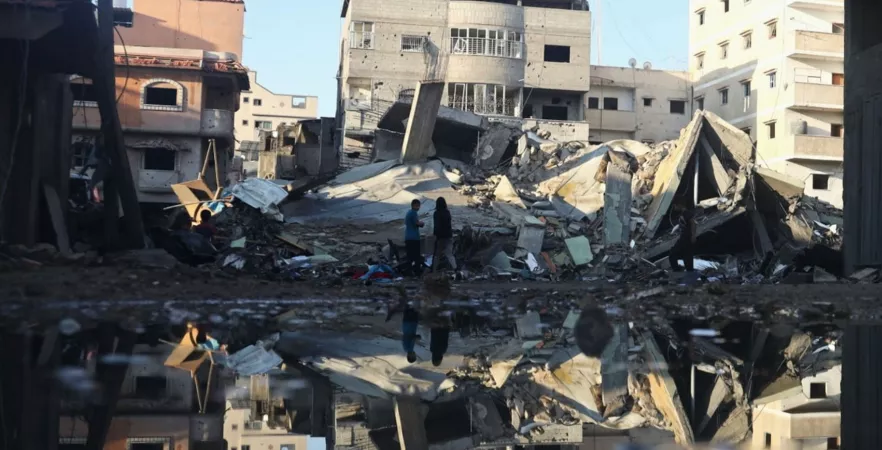 Children standing in front of rubble