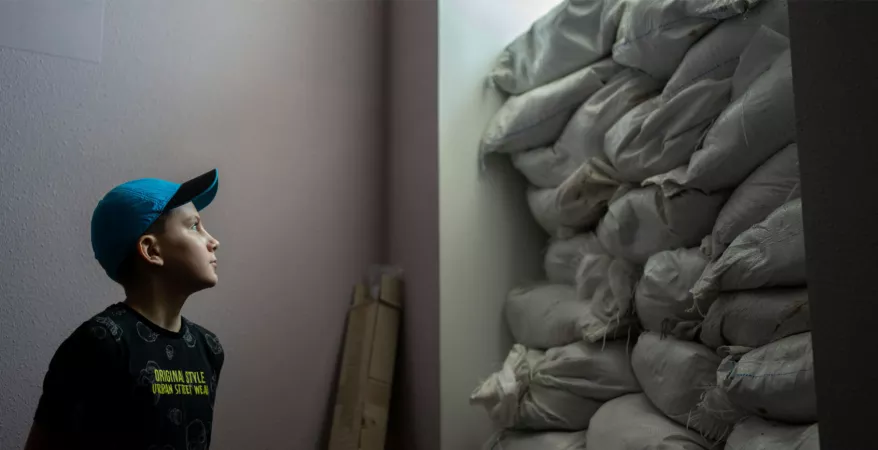 A boy looks towards a fortified wall of sand bags