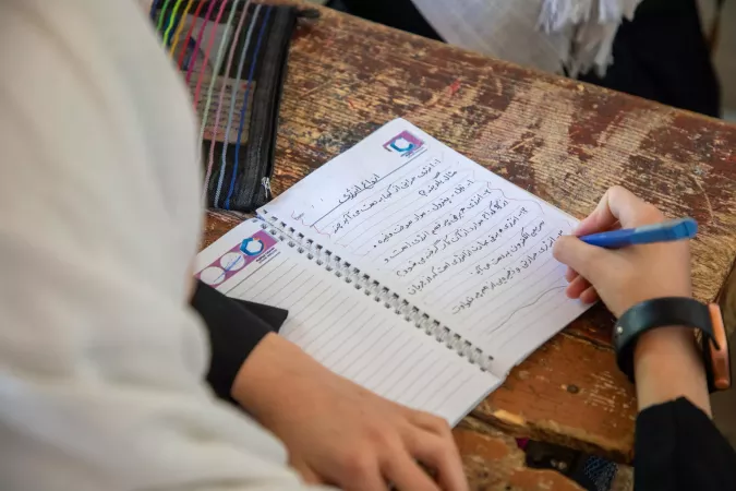Une jeune fille &eacute;crit sur son cahier