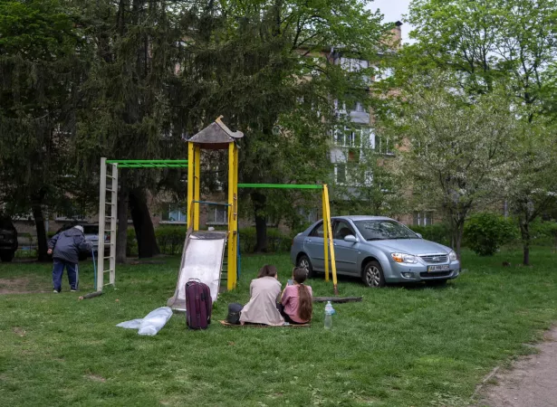 Kyiv, 24 April 2025. Residents who survived the missile attack rest in a residential courtyard, sitting near a playground with a few essential belongings. The attack killed 12 people, including three children, and injured 90 others.