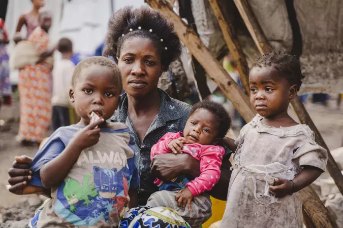 Masika Mukize sits with her children in front of their makeshift shelter in Goma, North Kivu province, DR Congo, on 4 February 2025.