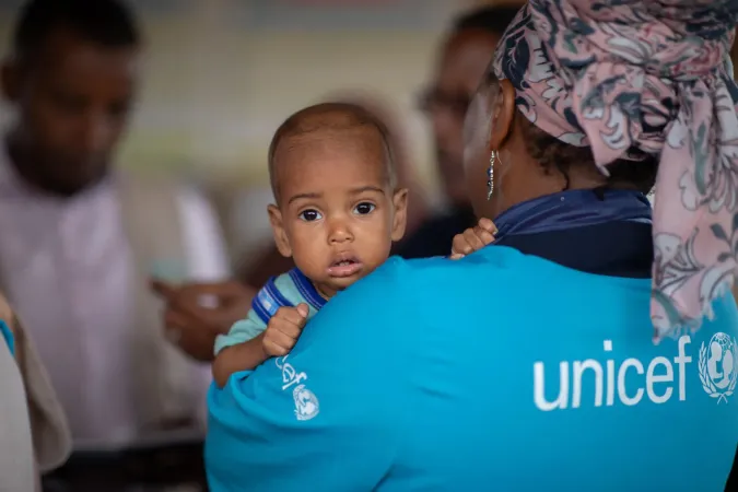 A UNICEF staff member holds a baby during a visit to the UNICEF-supported health and nutrition facility in Moqor iyo Mayow IDP settlement, 2026