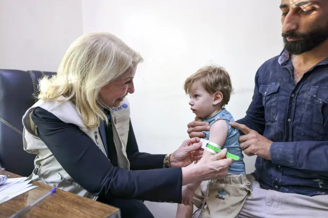 UNICEF Executive Director Catherine Russell carries out a nutrition screening for 20-month-old Imad Addin during a visit to a UNICEF-supported health centre in Duma, where he was attending a routine check-up with his father, Rural Damascus, Syria, 30 September 2026.