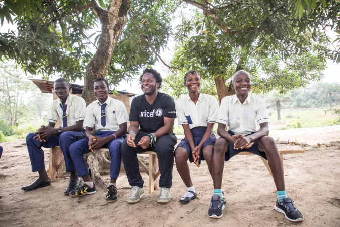 Ishmael talks with students learning life skills training to support healthy development. 