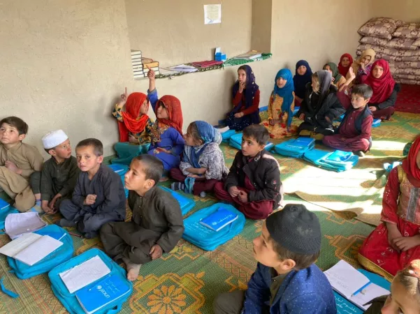 Afghanistan. Children sit on the floor in a classroom.