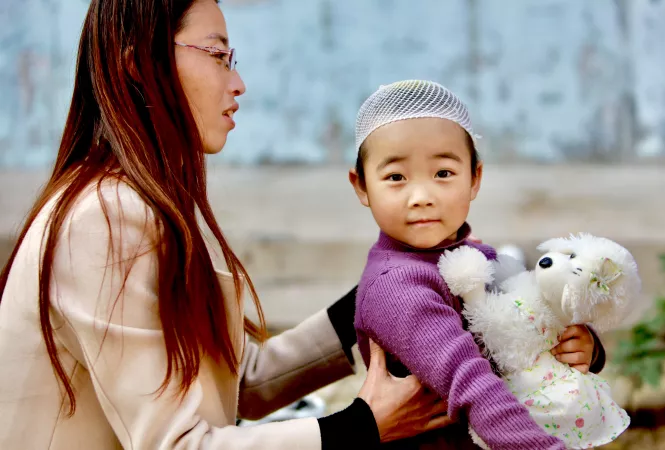 A woman sits with a young child in China, in 2017.